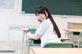 Student seated in classroom long hair looking over her shoulder