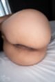 Knees drawn up round ass lying on bed