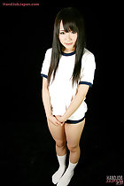 Standing in uniform long hair flowing down over her shoulders hands clasped together in white socks
