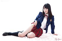Student seated wearing uniform raising skirt exposing thigh