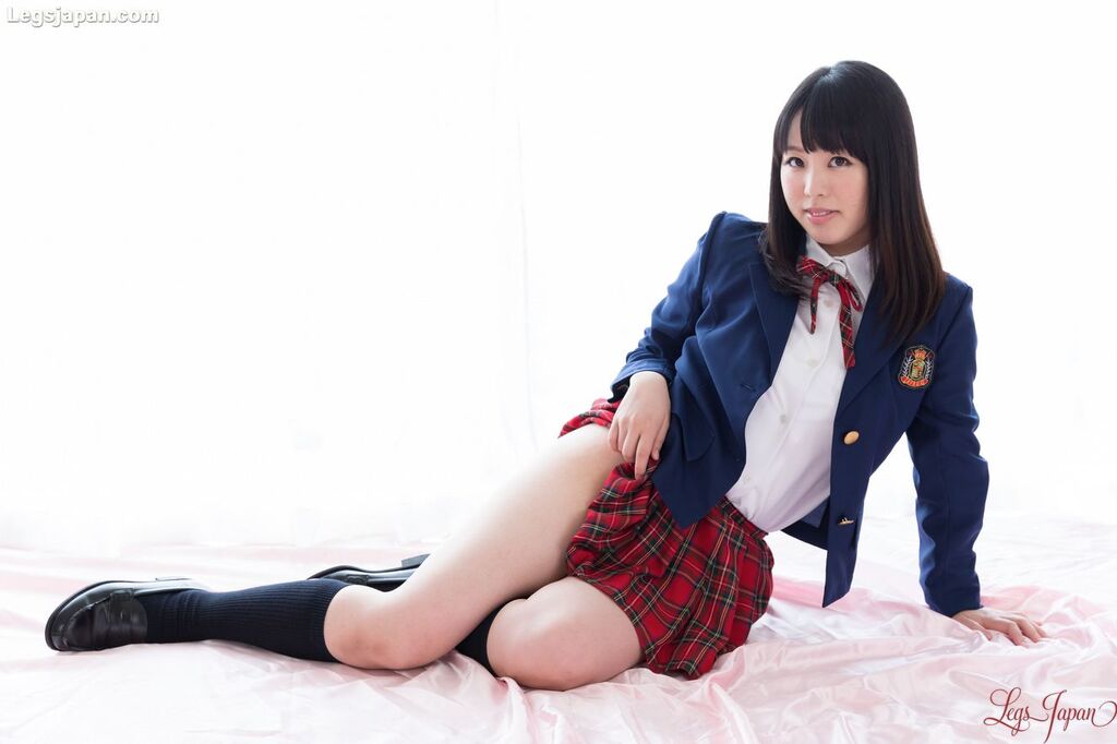 Student seated wearing uniform raising skirt exposing thigh