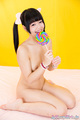 Kneeling nude hair in pigtails holding lollipop bare feet