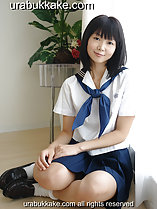 Seated on wood floor wearing kogal uniform hands clasped on her thigh