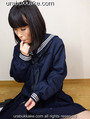 Seated on wooden floor in seifuku uniform sucking her finger.jpg